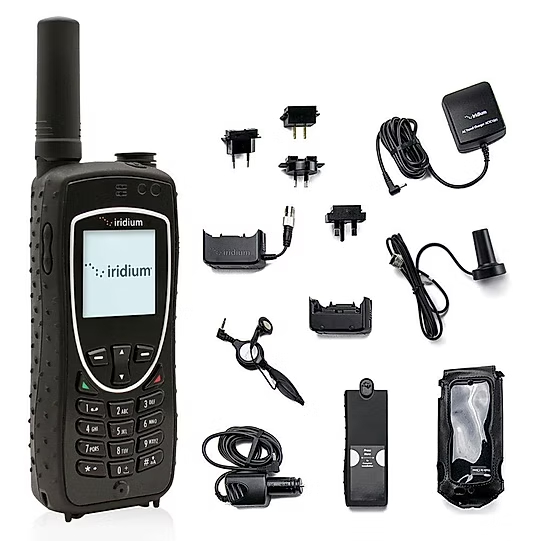 An Iridium satellite phone displayed with its full set of accessories, including chargers, adapters, and a carrying case.